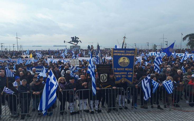 Κρατούν ελληνικές σημαίες και χορεύουν παραδοσιακούς χορούς